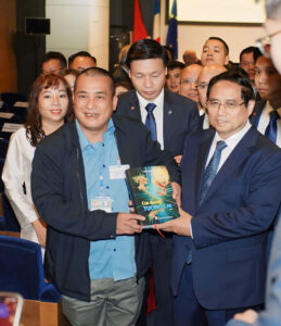 Thủ tướng Phạm Minh Chính và nhà văn Nguyễn Xuân Tuấn cầm trên tay cuốn sách Con đường tương lai tập 1 